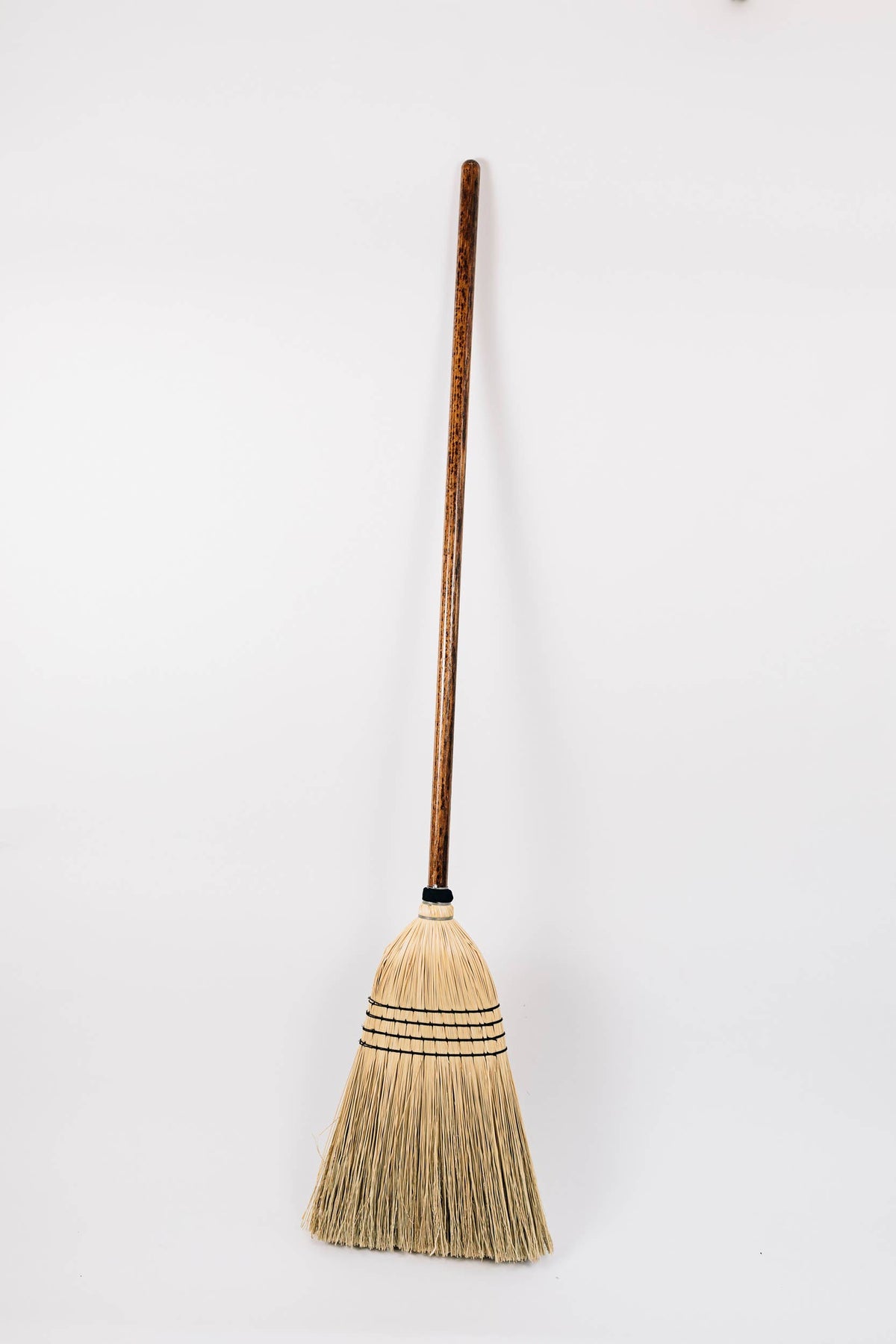 Full-length Natural broom with a long wooden handle and pale broom-corn bristles.