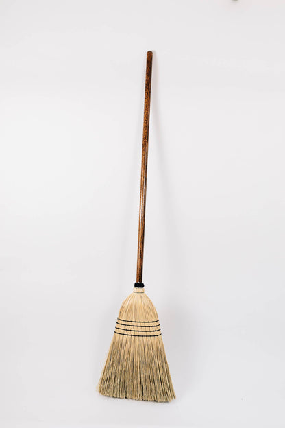 Full-length Natural broom with a long wooden handle and pale broom-corn bristles.