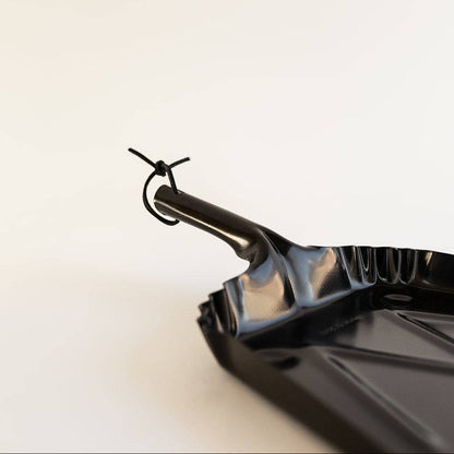 Close-up of the Farmhouse Dustpan's shiny black body and thin front edge.