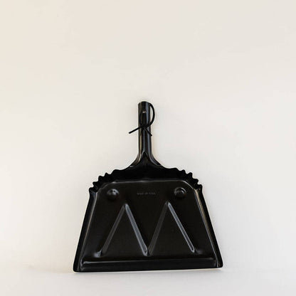 Front view of the black Farmhouse Dustpan showing its handle, hanging loop and wide edge.
