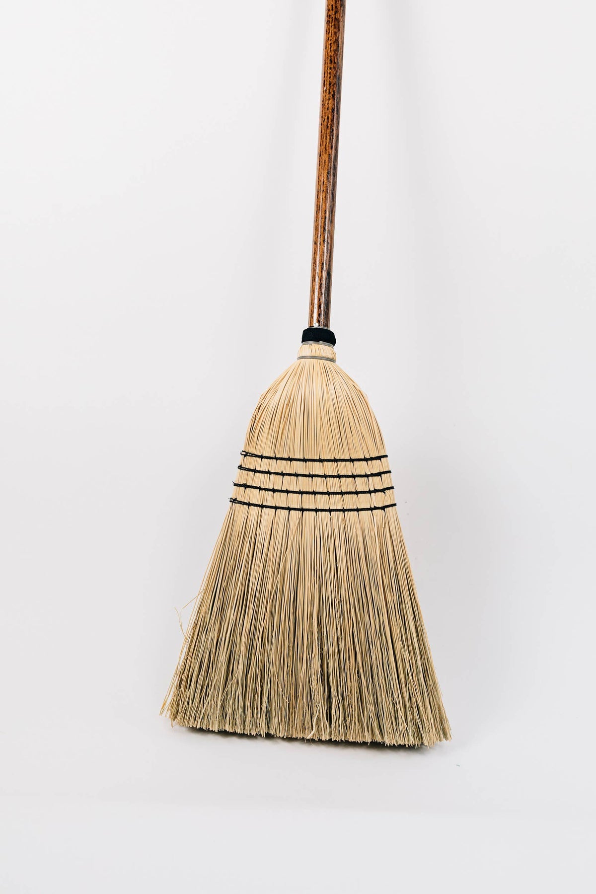 Detail of pale broom-corn bristles with dark stitching.