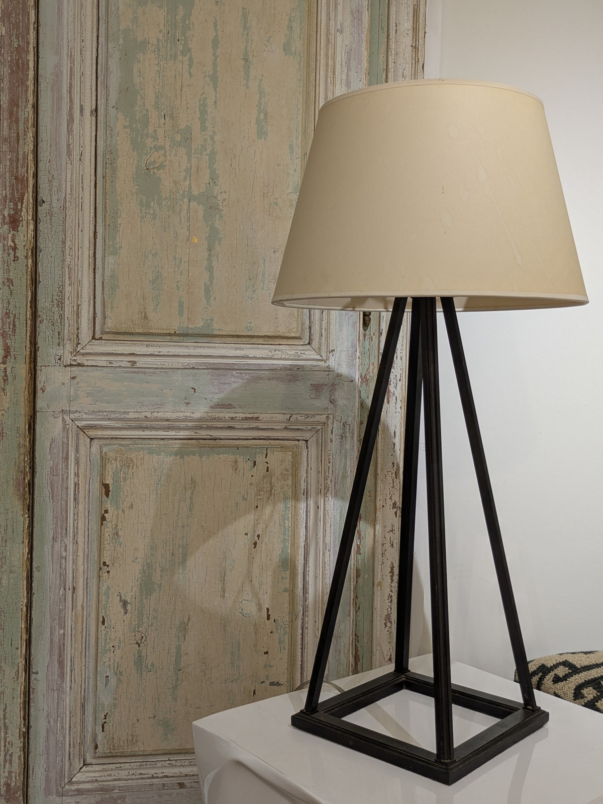 Complete view of Gaspard table lamp with tapered metal frame, square base and pale shade