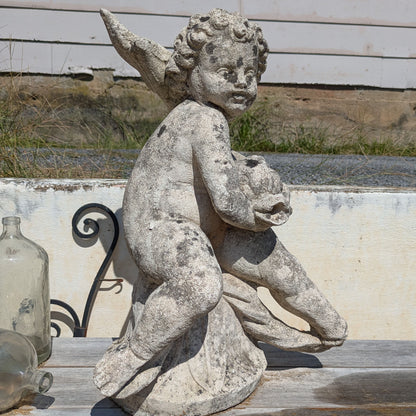 Side view of Concrete Water Sprite showing the figure's curly hair and the raised tail of the fish.