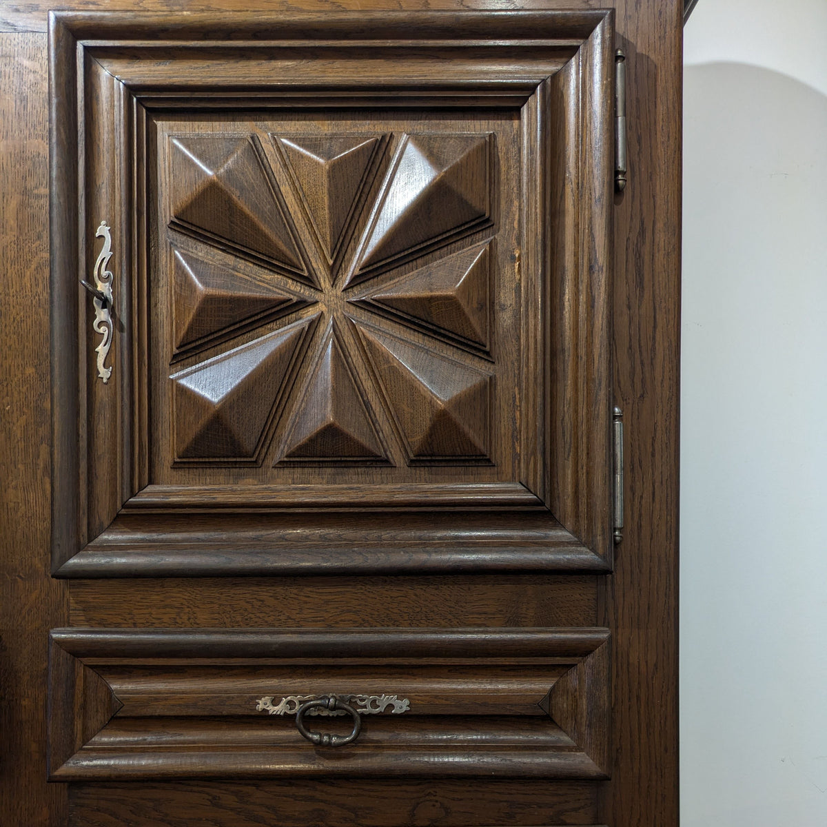 Detail of Izar Cabinet's starburst door panel, layered frame and metal drawer pull.