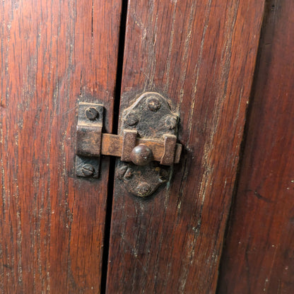 Close-up of Montel Low Cabinet's metal latch against the brown wood doors.