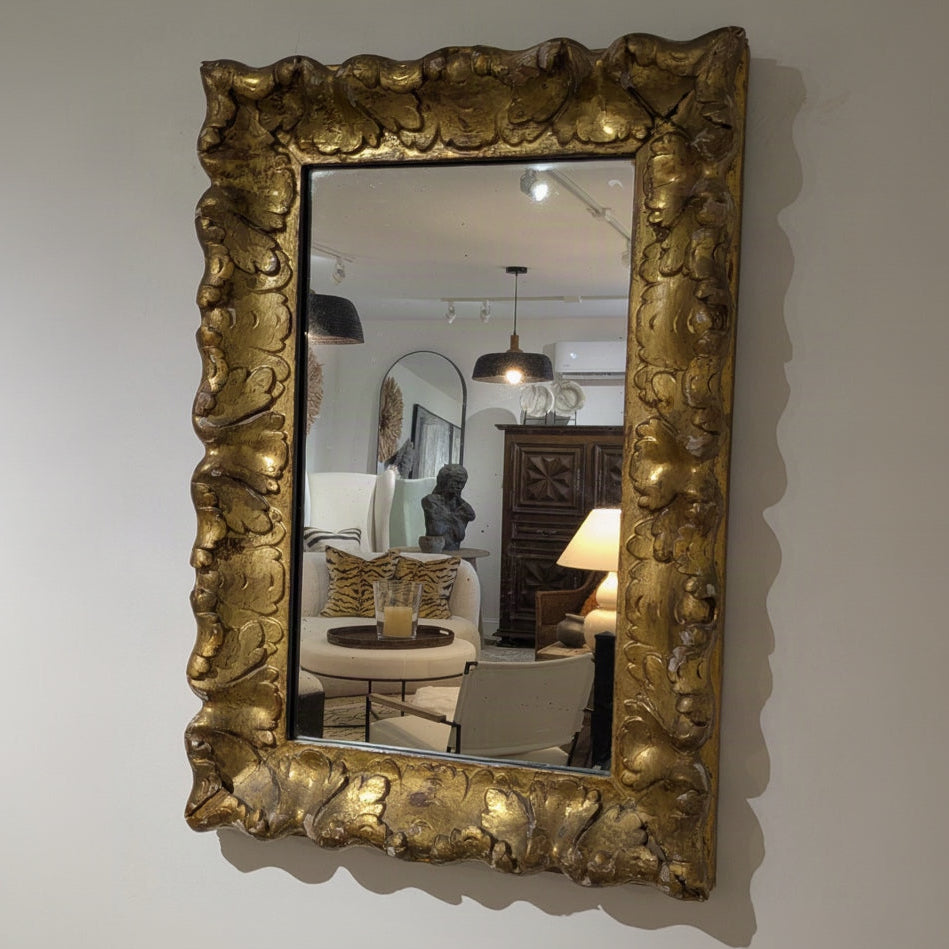 Angled view of Aurèle Wall Mirror showing its upright rectangular shape and sculpted gold-toned frame.