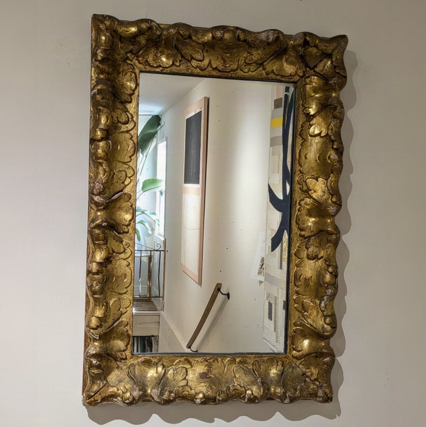 Aurèle Wall Mirror with a rectangular mirror and wide gold-toned scroll-and-leaf frame, mounted vertically.