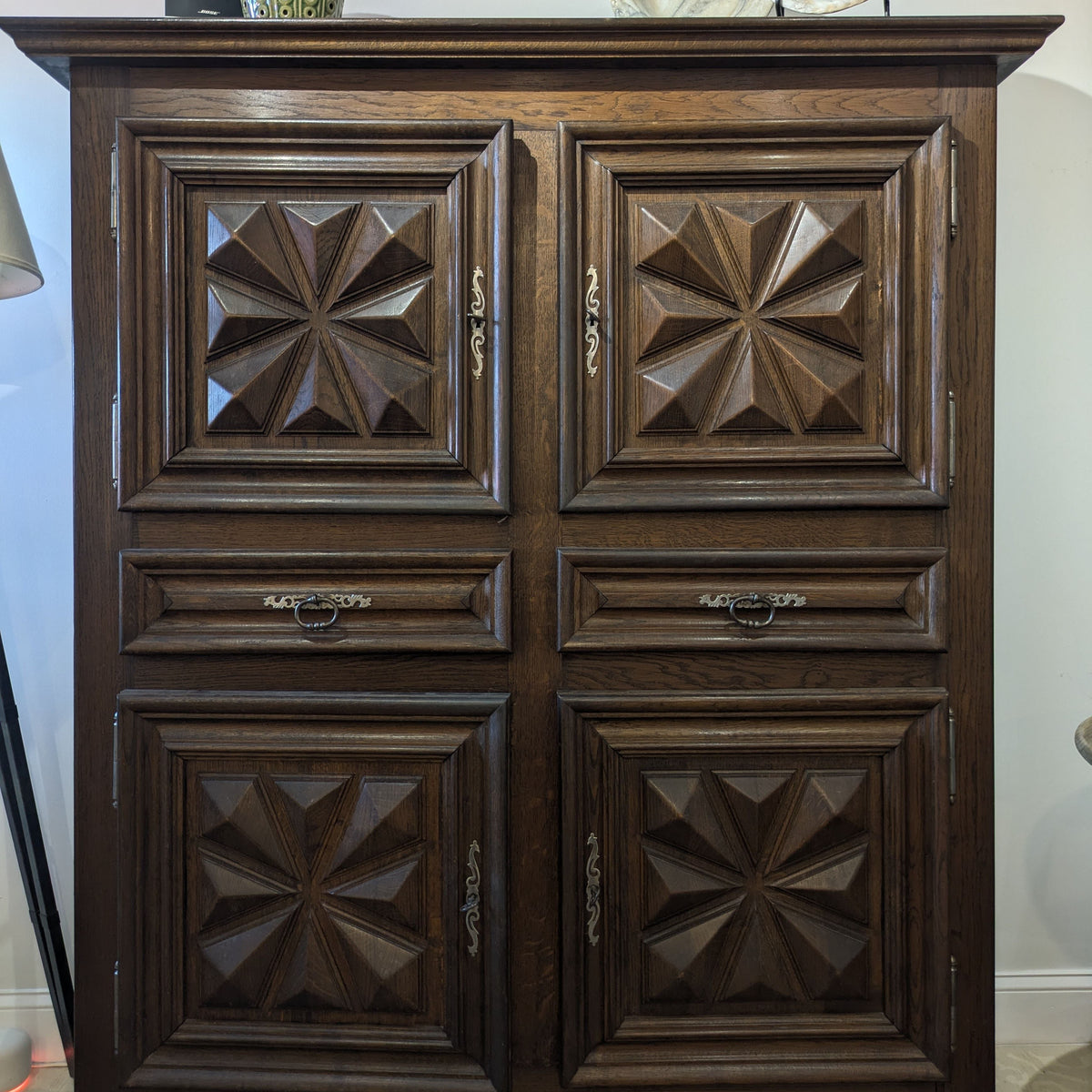 Front view of Izar Cabinet with four starburst-paneled doors, two drawers and a projecting cornice.